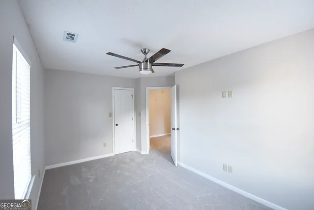 a view of a big room with wooden floor and windows