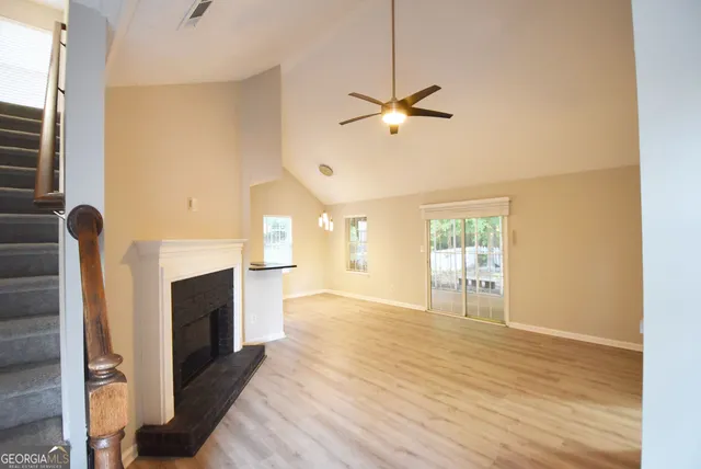 a view of an empty room with a fireplace and a window