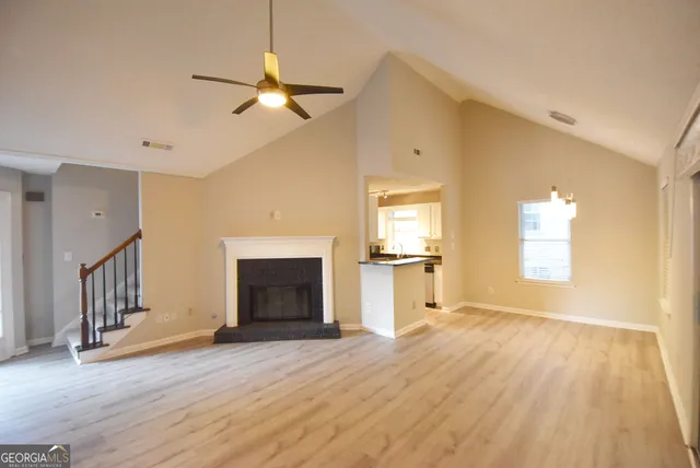 a view of empty room with wooden floor and fireplace