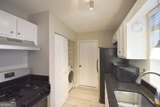 a kitchen with stainless steel appliances granite countertop a refrigerator and a stove