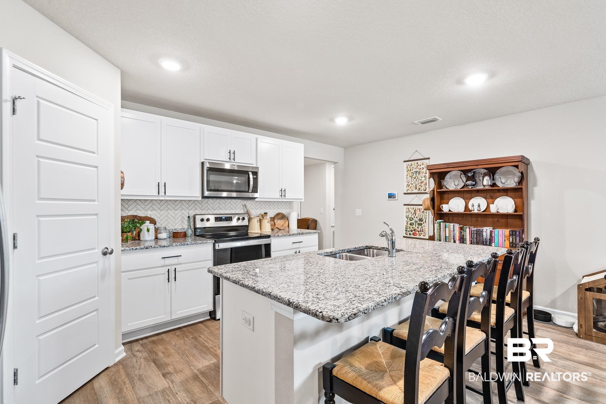 10516 Brodick Loop Daphne, AL 36527 - Photo 4 of 27 Kitchen with stainless steel appliances, sink, white cabinetry, and light hardwood / wood-style floors