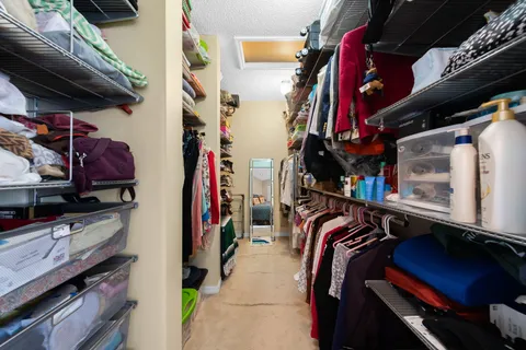 a view of walk in closet with clothes and shoes