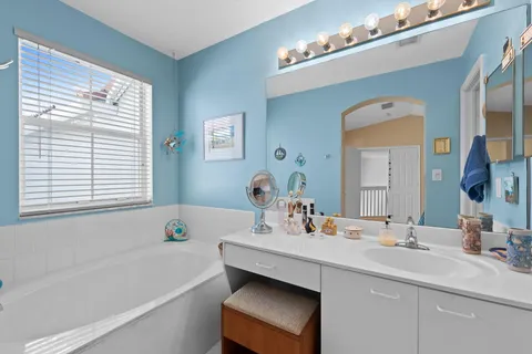 a bathroom with a sink double vanity granite tub and a mirror