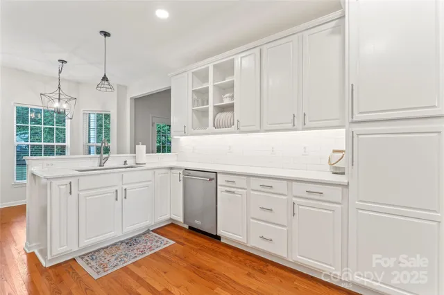 a kitchen with white cabinets and sink