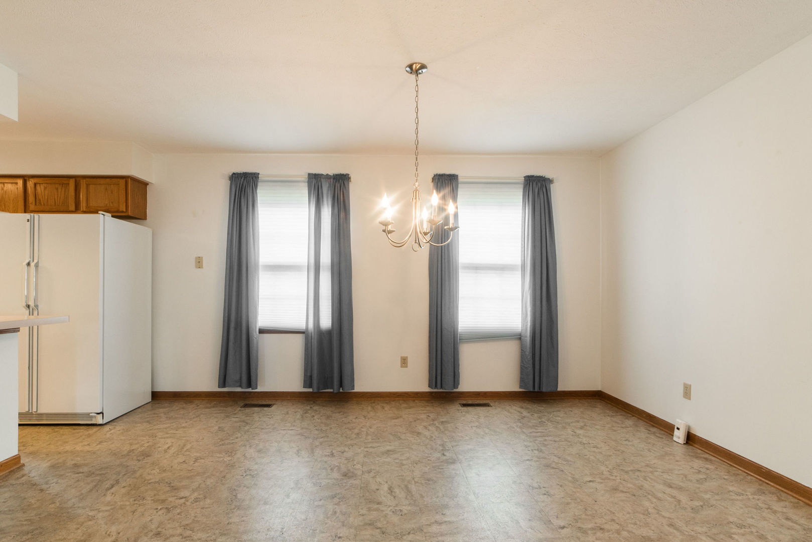 434 South Peace Road, Unit 434 Sycamore, IL 60178 - Photo 11 of 22 an empty room with chandelier fan and windows