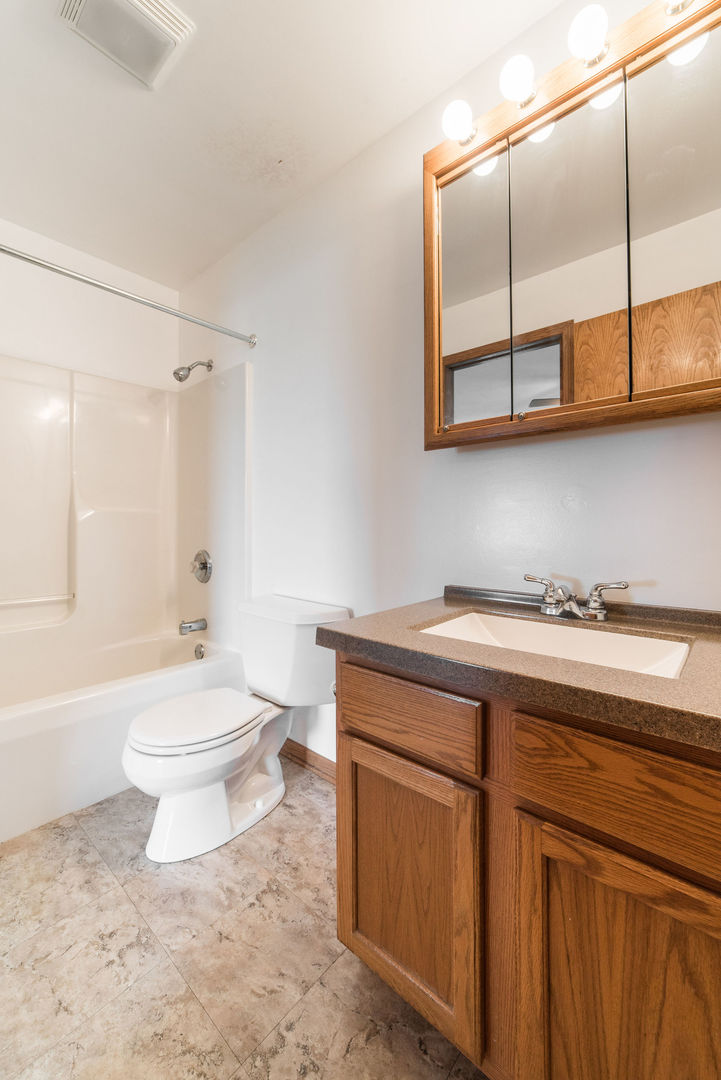 434 South Peace Road, Unit 434 Sycamore, IL 60178 - Photo 16 of 22 a bathroom with a granite countertop toilet a sink and a bathtub