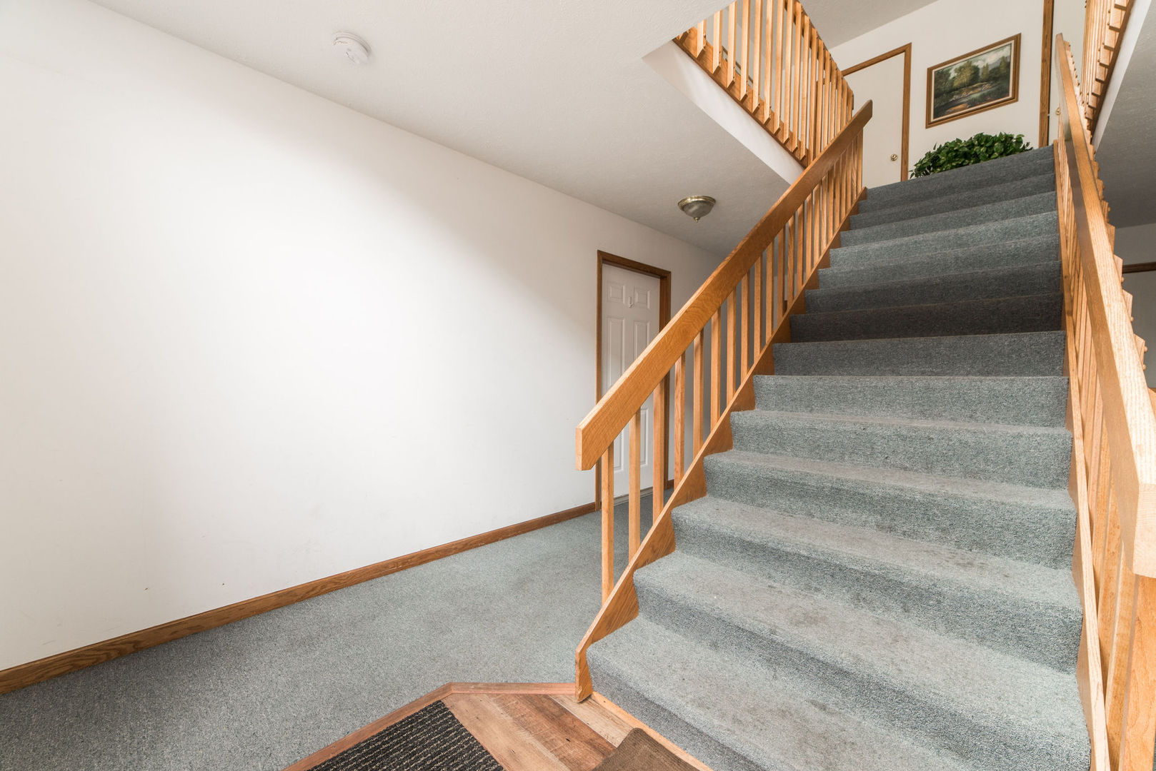 434 South Peace Road, Unit 434 Sycamore, IL 60178 - Photo 21 of 22 a view of staircase with lots of frames on wall and a potted plant