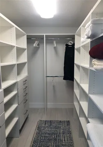 a view of walk in closet with empty racks