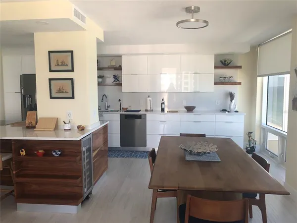 a kitchen with a table chairs refrigerator and cabinets