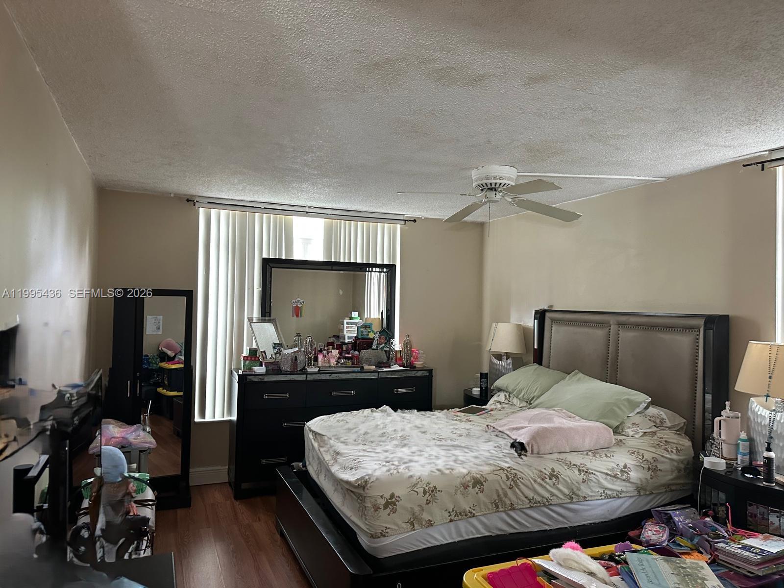3720 Inverrary Drive, Unit 1J Lauderhill, FL 33319 - Photo 21 of 24 a bedroom with a bed and wooden floor