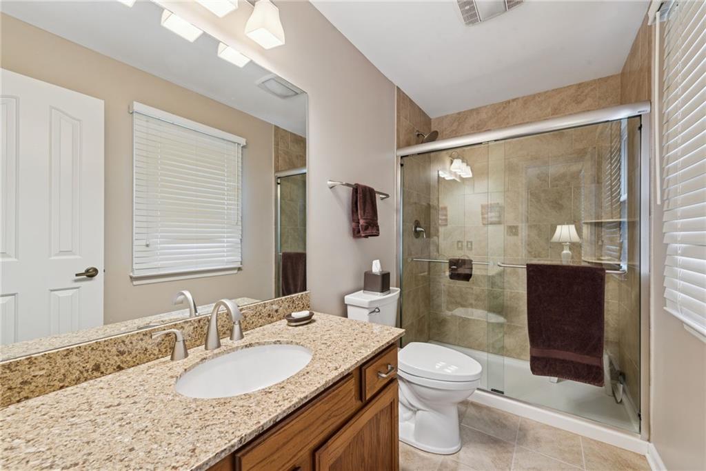 601 Timber Lane Sewickley, PA 15143 - Photo 19 of 45 a bathroom with a granite countertop sink toilet a large mirror a shower and a mirror