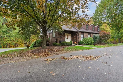 a view of a house with a tree in front of it
