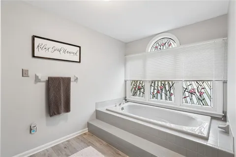a bathroom with a bathtub and a window
