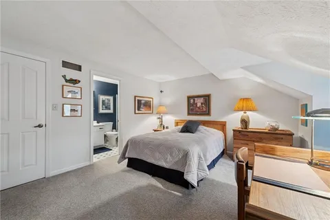 a spacious bedroom with a bed and wooden floor