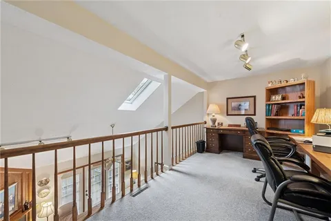 a view of a workspace with furniture and a window