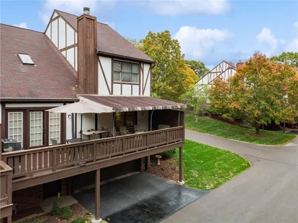 a view of a house with wooden deck and a yard