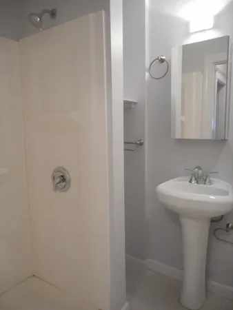 a bathroom with a sink a mirror and shower