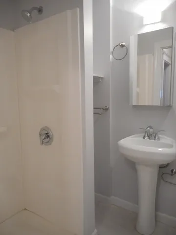 a bathroom with a sink a mirror and shower