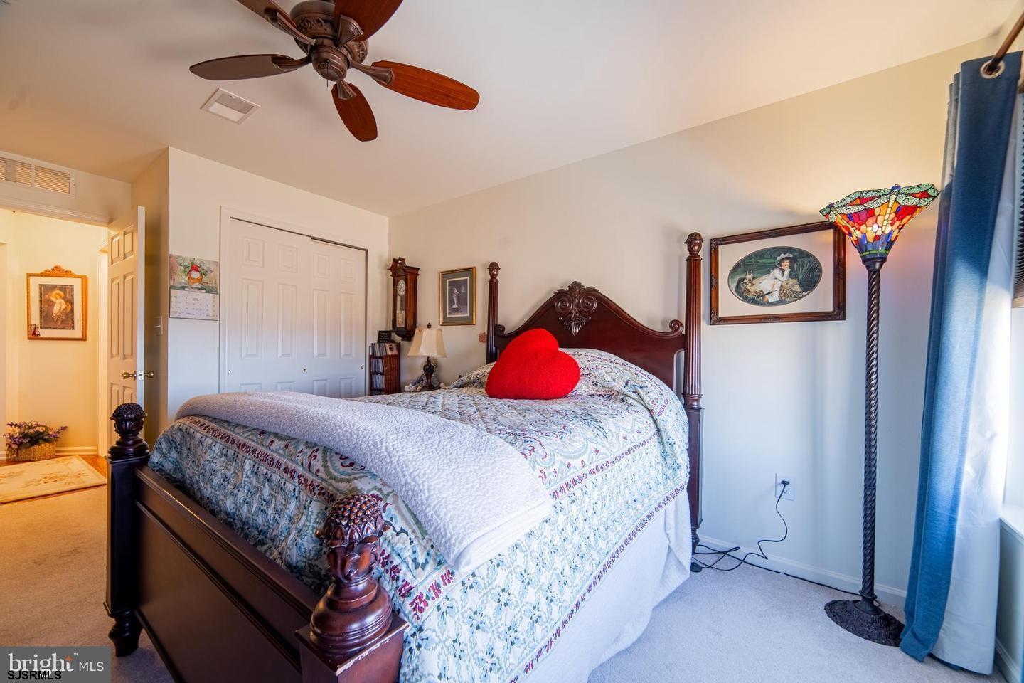 61 Dockside Drive, Unit 61 Somers Point, NJ 08244 - Photo 11 of 20 a bedroom with a bed and a chandelier