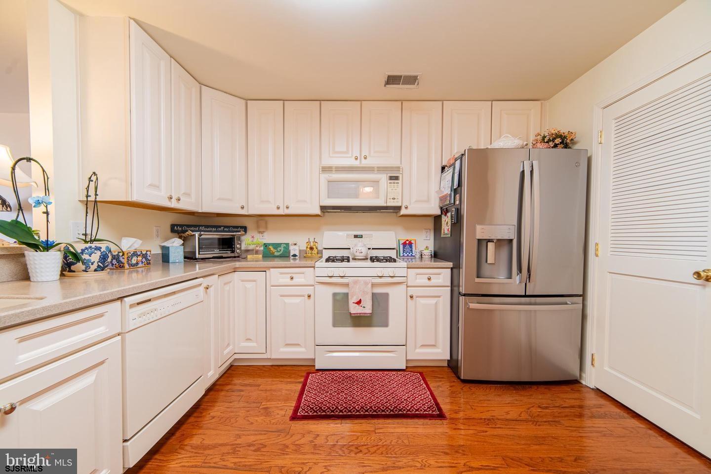 61 Dockside Drive, Unit 61 Somers Point, NJ 08244 - Photo 13 of 20 a kitchen with white cabinets and white appliances