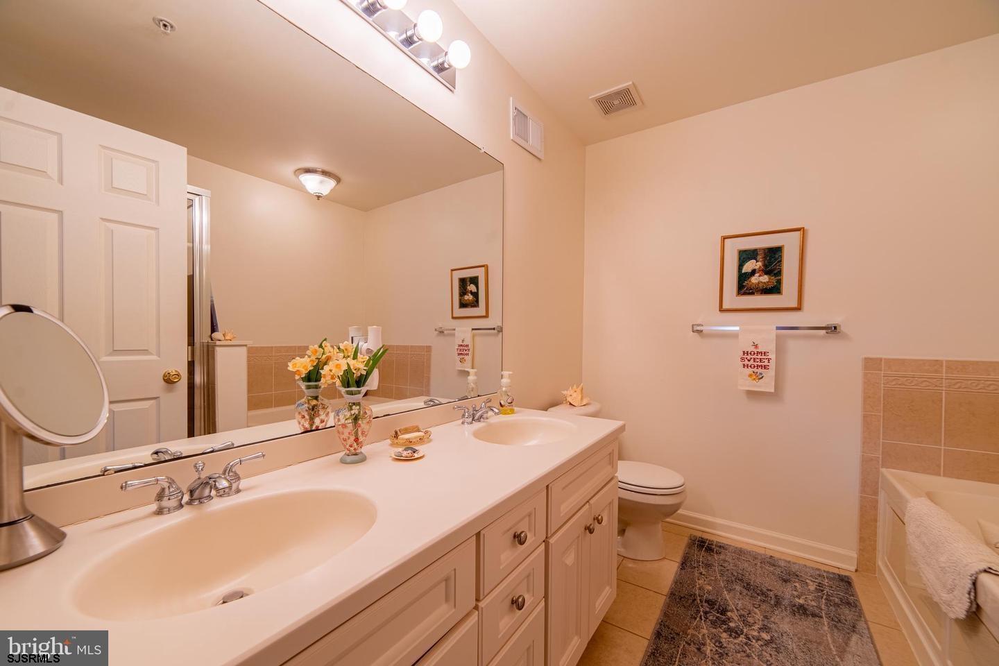61 Dockside Drive, Unit 61 Somers Point, NJ 08244 - Photo 15 of 20 a bathroom with a double vanity sink mirror and toilet