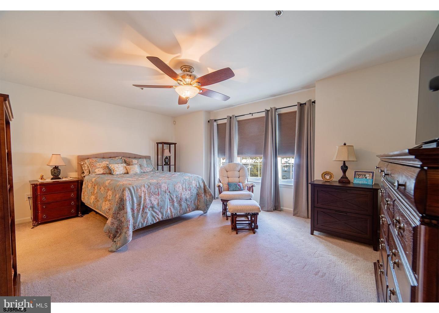 61 Dockside Drive, Unit 61 Somers Point, NJ 08244 - Photo 17 of 20 a spacious bedroom with a bed and a chandelier