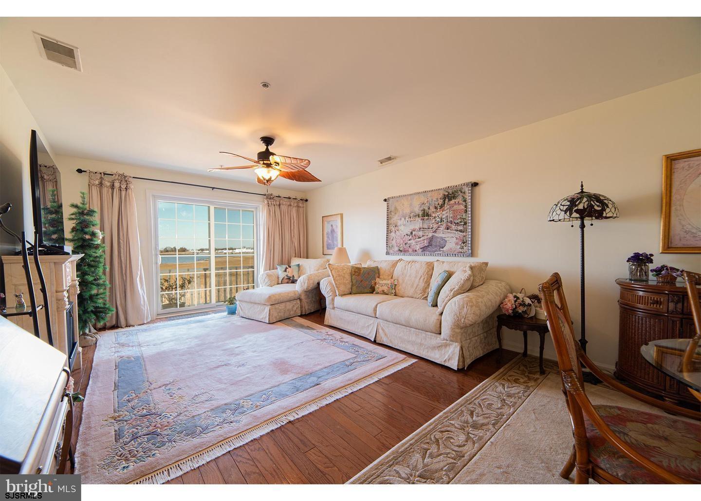 61 Dockside Drive, Unit 61 Somers Point, NJ 08244 - Photo 2 of 20 a living room with furniture large window and a table
