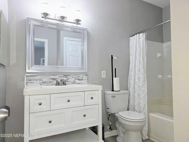 a bathroom with a toilet a sink and a mirror