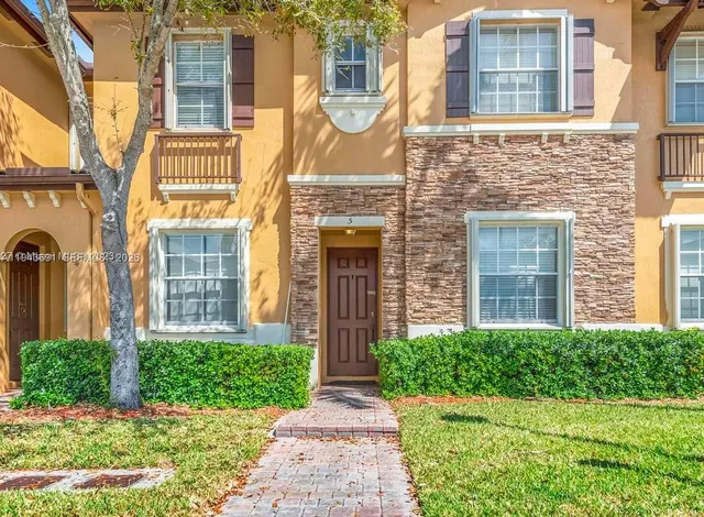 front view of a brick house with a small yard