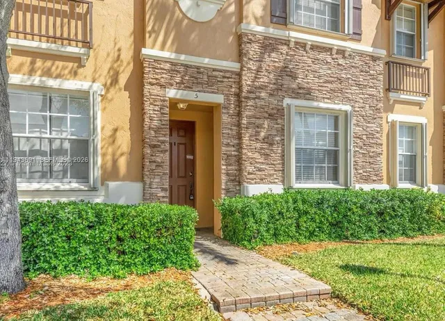front view of a brick house with a yard