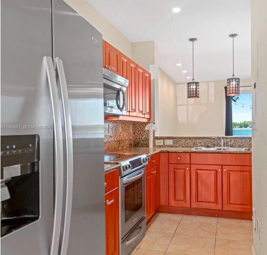 9155 Southwest 227th Street, Unit 5 Cutler Bay, FL 33190 - Photo 4 of 8 a kitchen with stainless steel appliances granite countertop a refrigerator and a sink