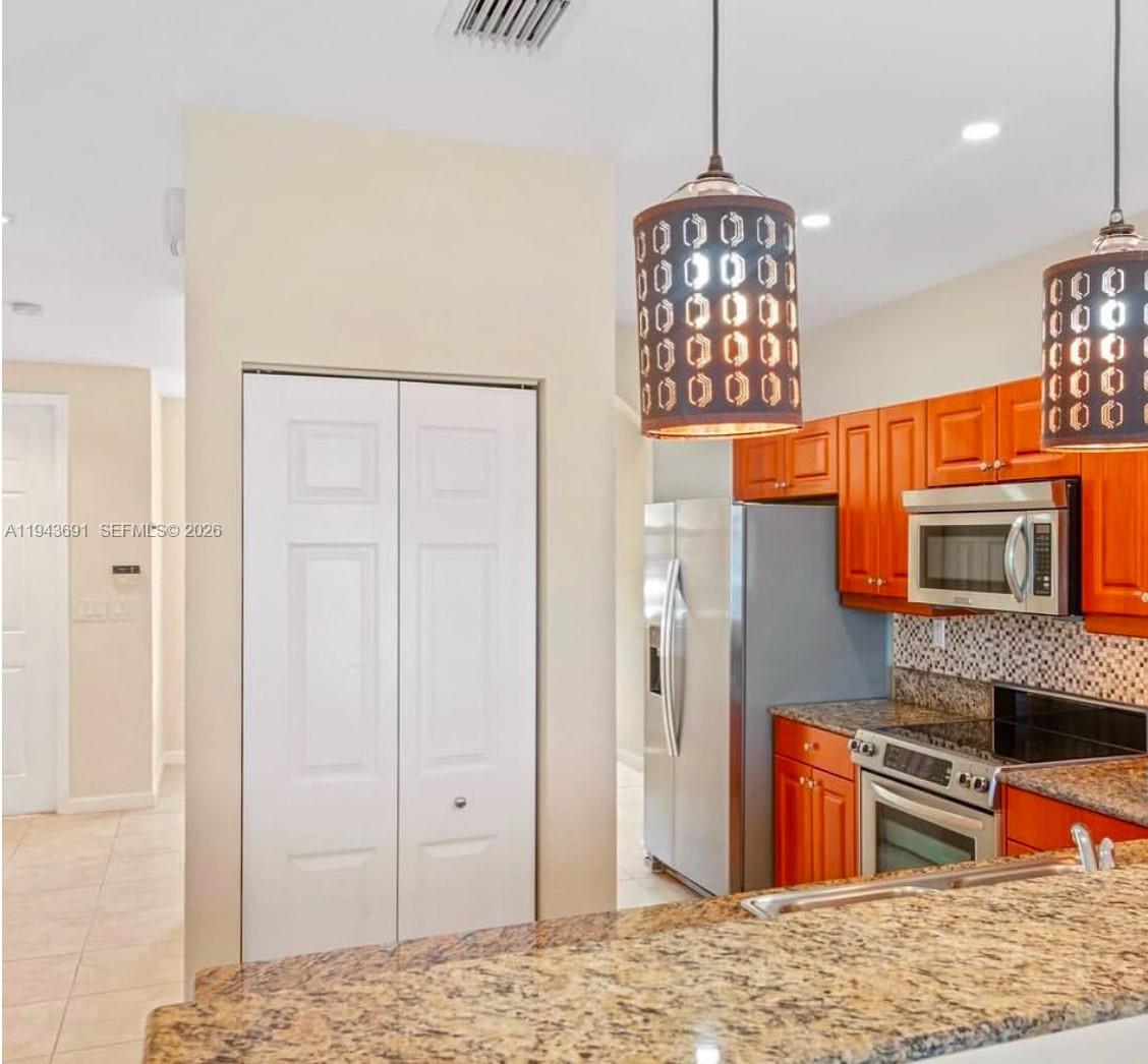 9155 Southwest 227th Street, Unit 5 Cutler Bay, FL 33190 - Photo 5 of 8 a living room with stainless steel appliances kitchen island granite countertop furniture and a kitchen view