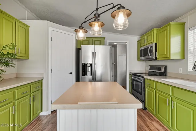 a kitchen with stainless steel appliances a table chairs refrigerator and microwave