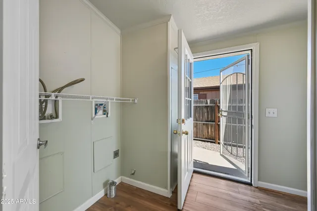 a view of a hallway with wooden floor and entryway