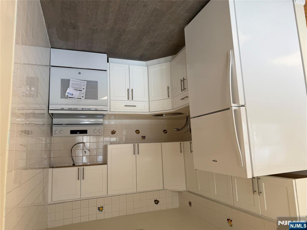 419 Paterson Avenue East Rutherford, NJ 07073 - Photo 3 of 5 a kitchen with white cabinets and white appliances