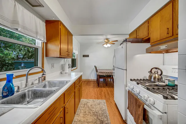 a kitchen with granite countertop a sink a counter space and cabinets