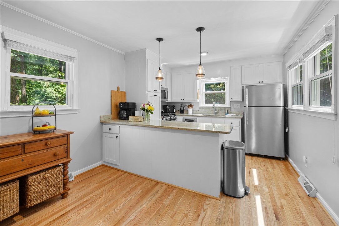 203 Augusta Road Clemson, SC 29631 - Photo 13 of 31 A well-lit kitchen with natural light and rich hardwood flooring, perfect for daily living.
