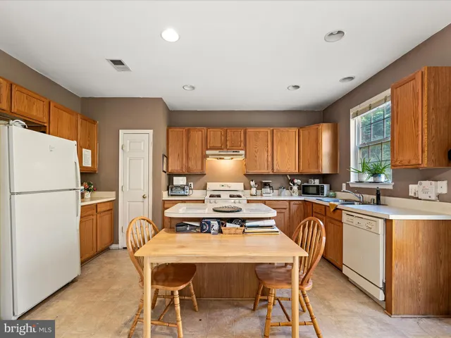 a kitchen with a stove a sink dishwasher and a refrigerator