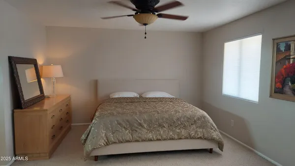 a bedroom with a bed tv and a window