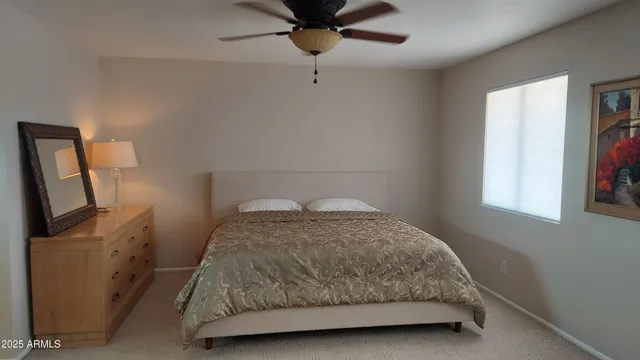 a bedroom with a bed tv and a window