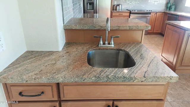 a kitchen with granite countertop a sink and a stove