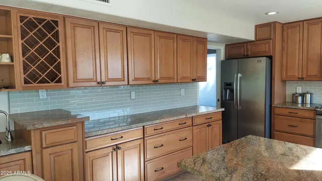 a kitchen with stainless steel appliances granite countertop a refrigerator and a sink