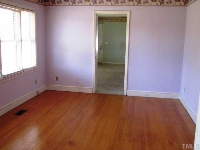 1308 Bacon Road Timberlake, NC 27583 - Photo 5 of 12 an empty room with wooden floor and windows