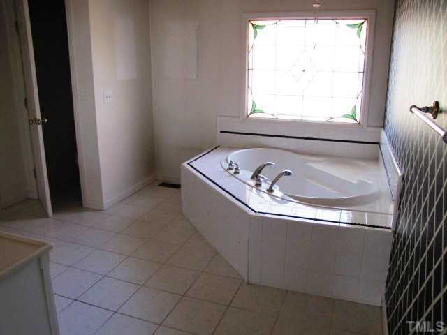 1308 Bacon Road Timberlake, NC 27583 - Photo 7 of 12 a bath tub sitting in a bathroom next to a window