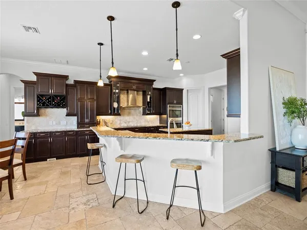 a large kitchen with kitchen island a large counter top space appliances and cabinets