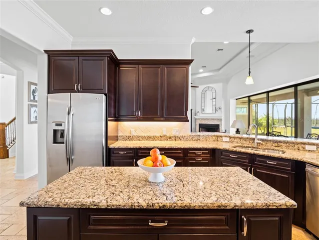 a kitchen with stainless steel appliances granite countertop a refrigerator a stove and a sink