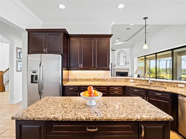 a kitchen with stainless steel appliances granite countertop a refrigerator a stove and a sink
