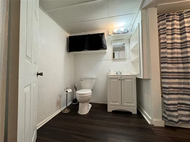 a living room with a toilet and a flat screen tv