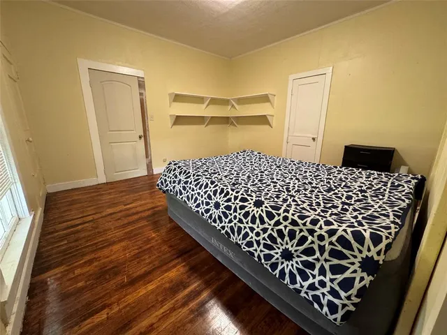 a bedroom with a bed and wooden floor