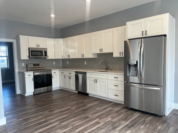 a kitchen with white cabinets and stainless steel appliances